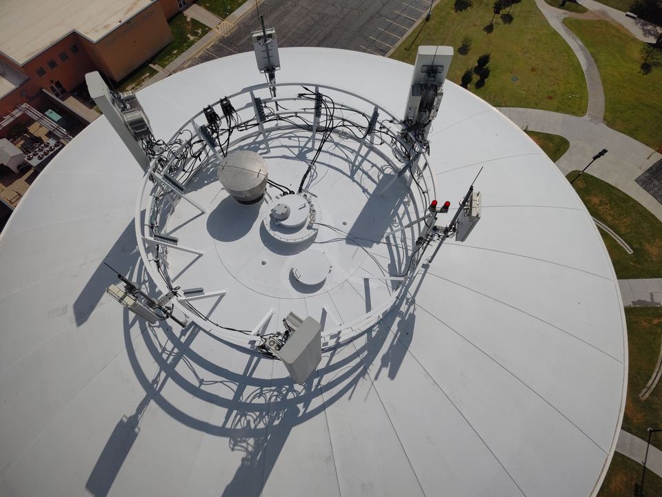 Overhead aerial view of a municipal water tower roof and antenna array